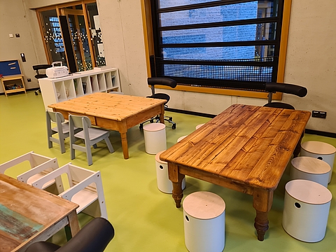 Tische mit Geschichte und aufgearbeitete Stühle haben wir mit Hockern und Stühlchen aus nachhaltigen Materialien kombiniert. 